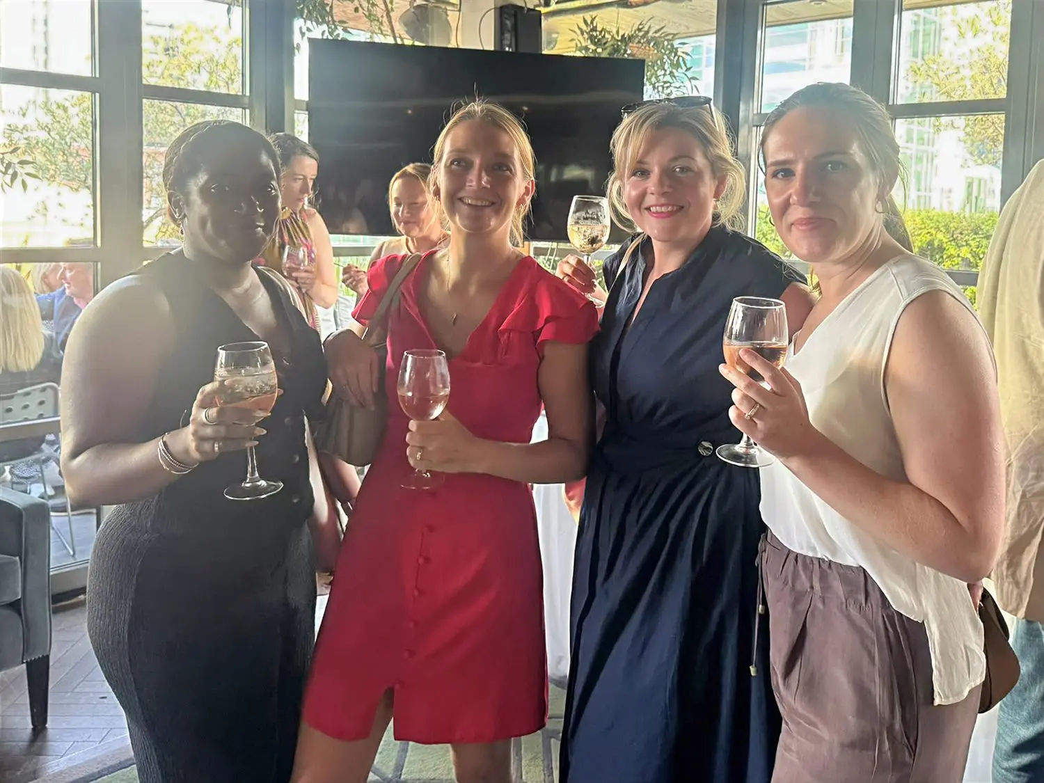 Members raising a glass of rose at the Summer Party