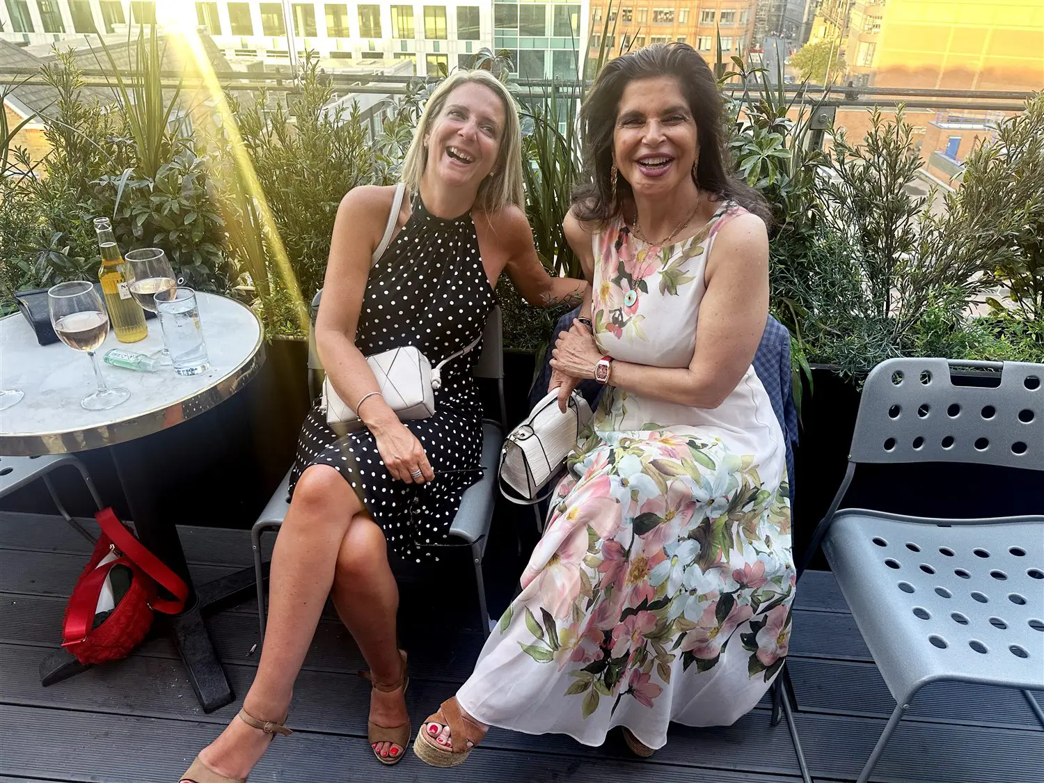 Two members share a laugh on the roof terrace at sunset